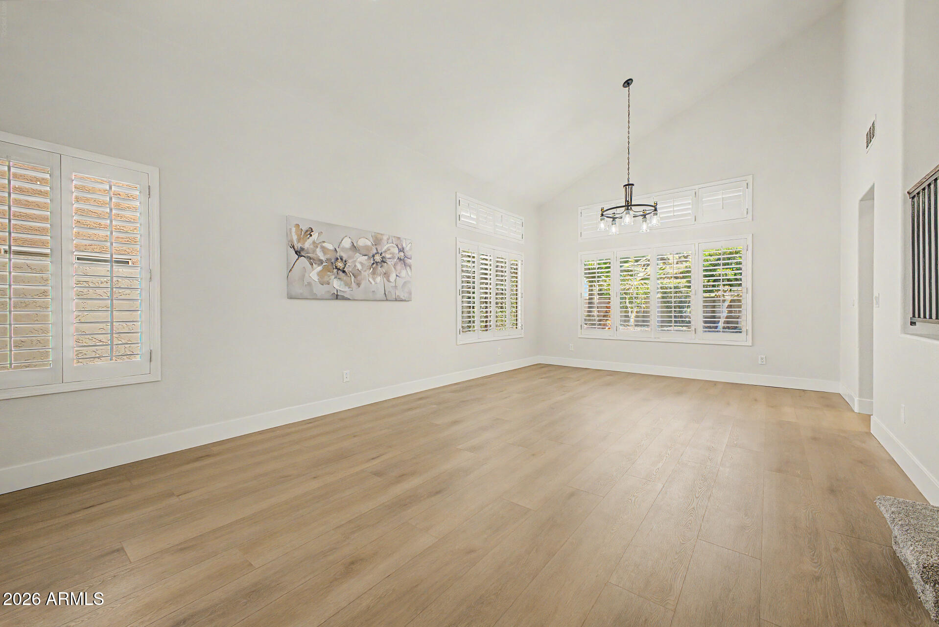 1743 East Redfield Road Gilbert, AZ 85234 - Photo 5 of 30 a view of an empty room with a window and wooden floor