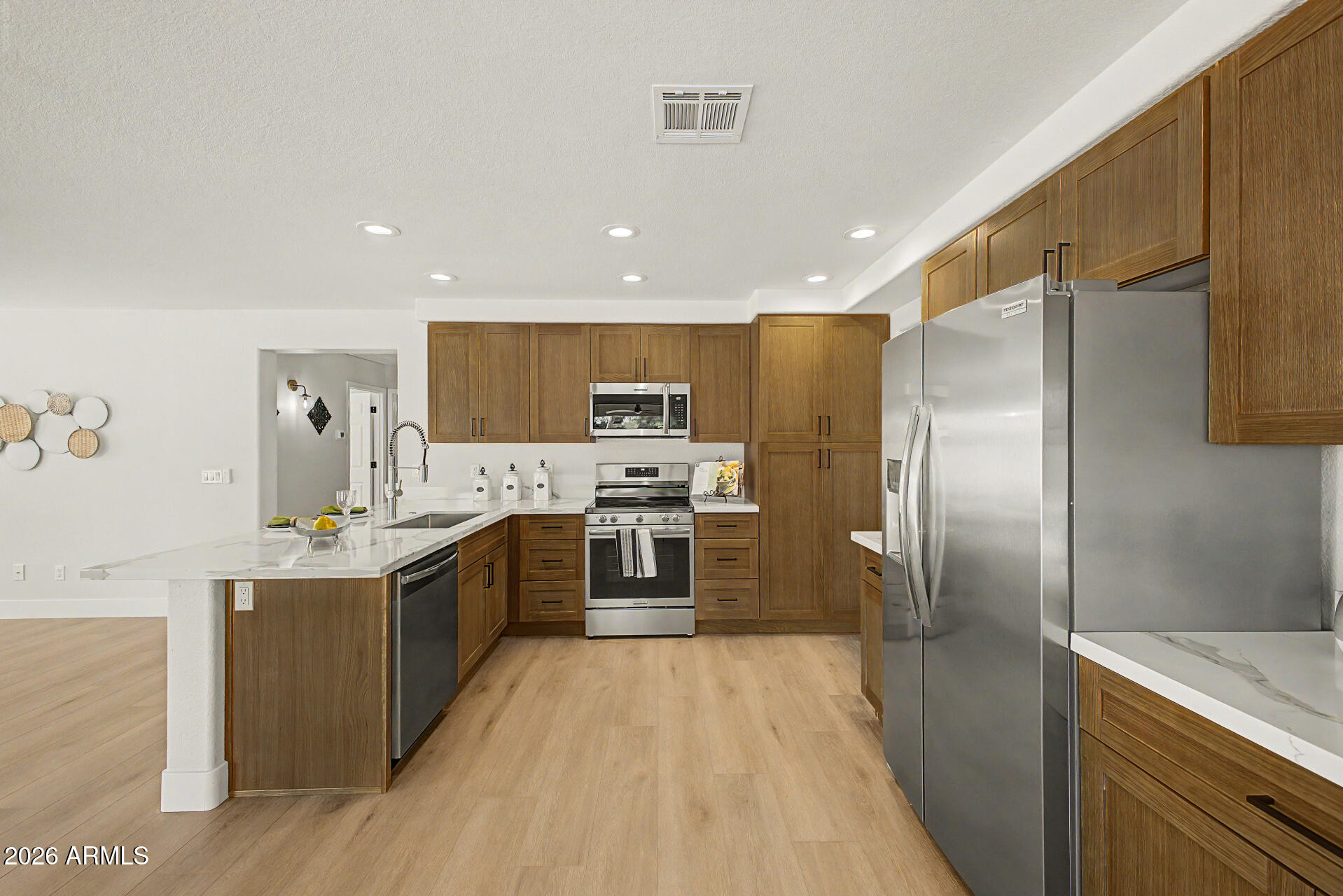 1743 East Redfield Road Gilbert, AZ 85234 - Photo 9 of 30 a large kitchen with stainless steel appliances kitchen island a sink stove and refrigerator