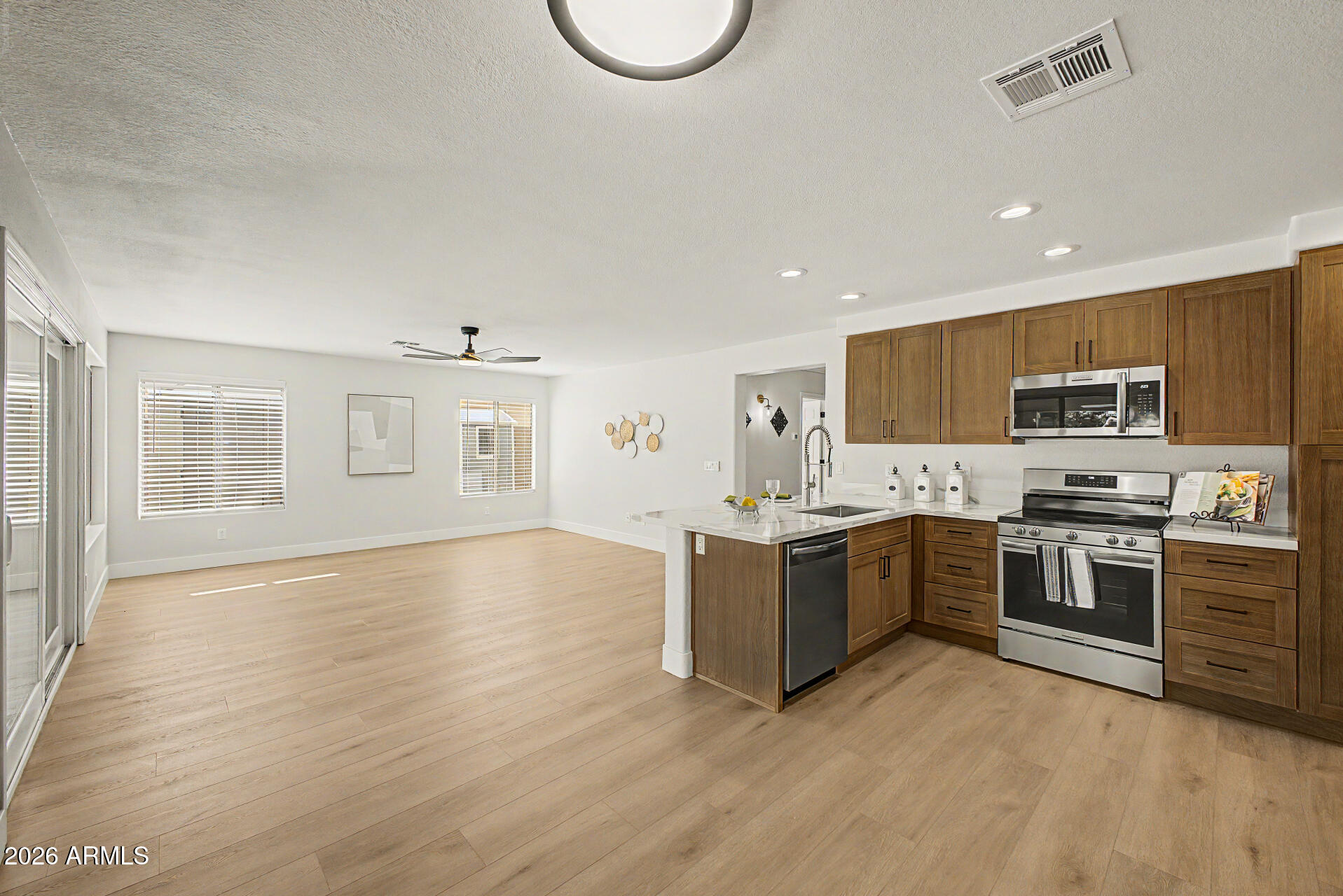 1743 East Redfield Road Gilbert, AZ 85234 - Photo 10 of 30 a large kitchen with cabinets wooden floor and stainless steel appliances