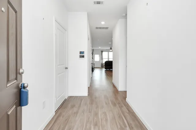 a view of a hallway with wooden floor