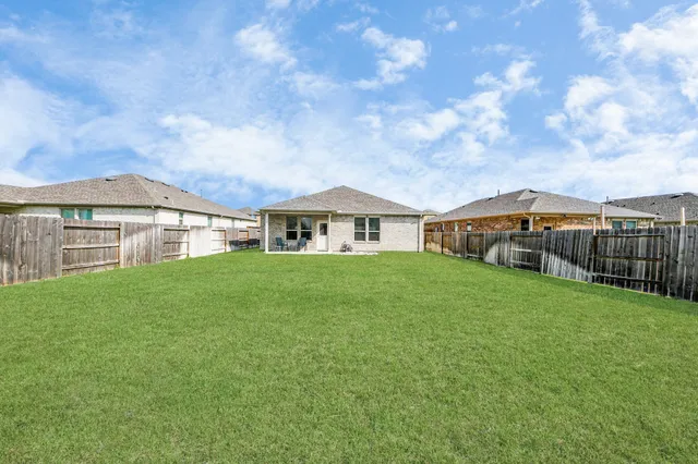 a view of an house with backyard space and balcony