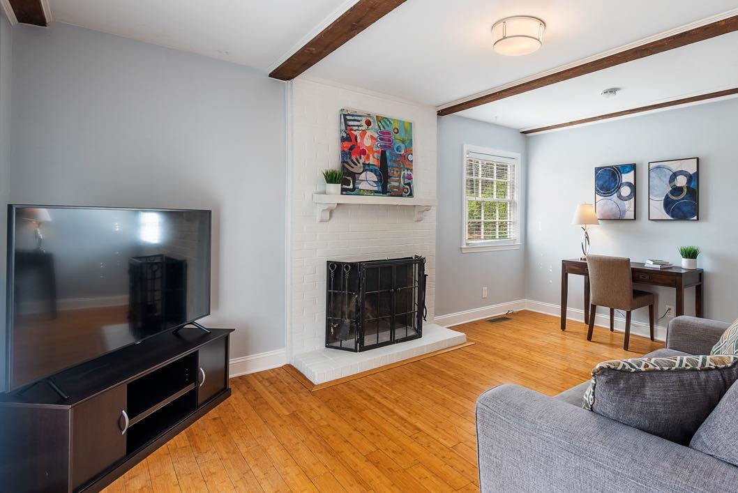 5614 Pelham Road Durham, NC 27713 - Photo 5 of 37 a living room with furniture a flat screen tv and a fireplace