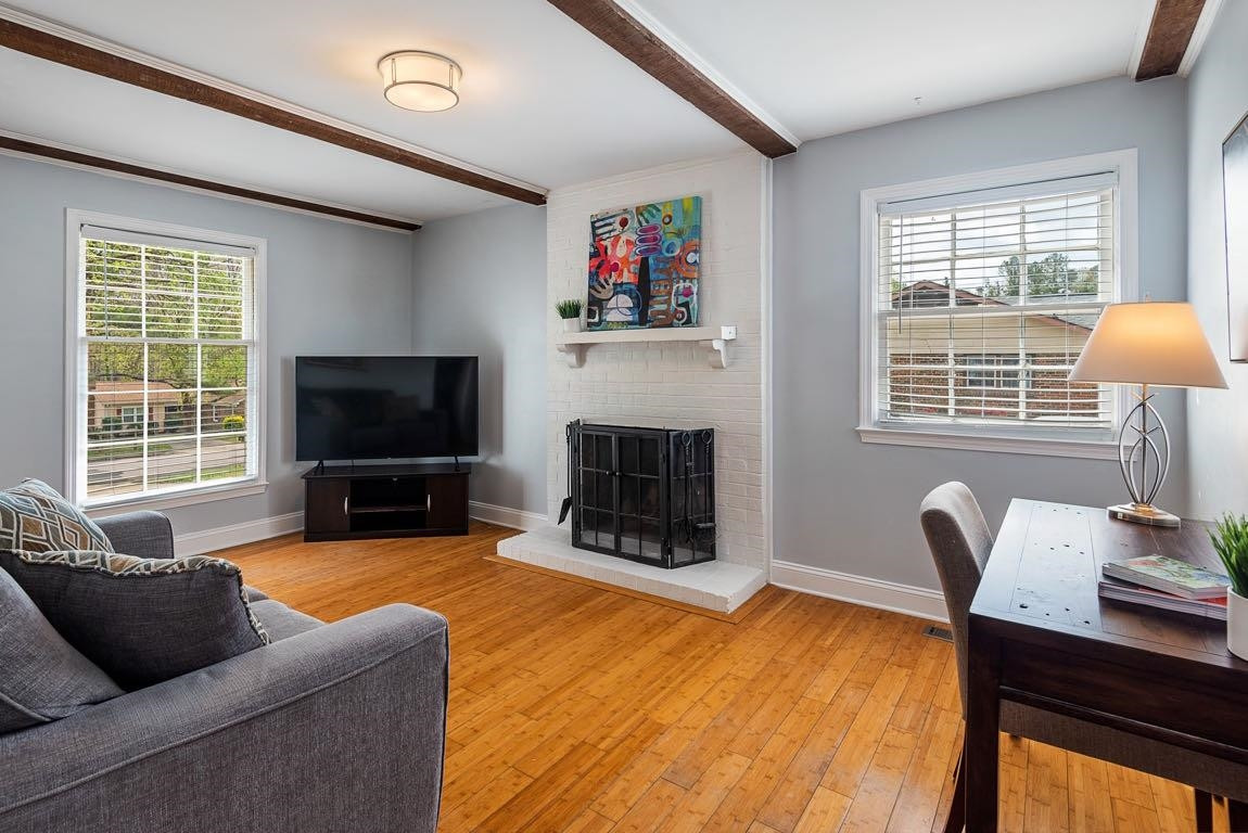 5614 Pelham Road Durham, NC 27713 - Photo 6 of 37 a living room with furniture a flat screen tv and a fireplace