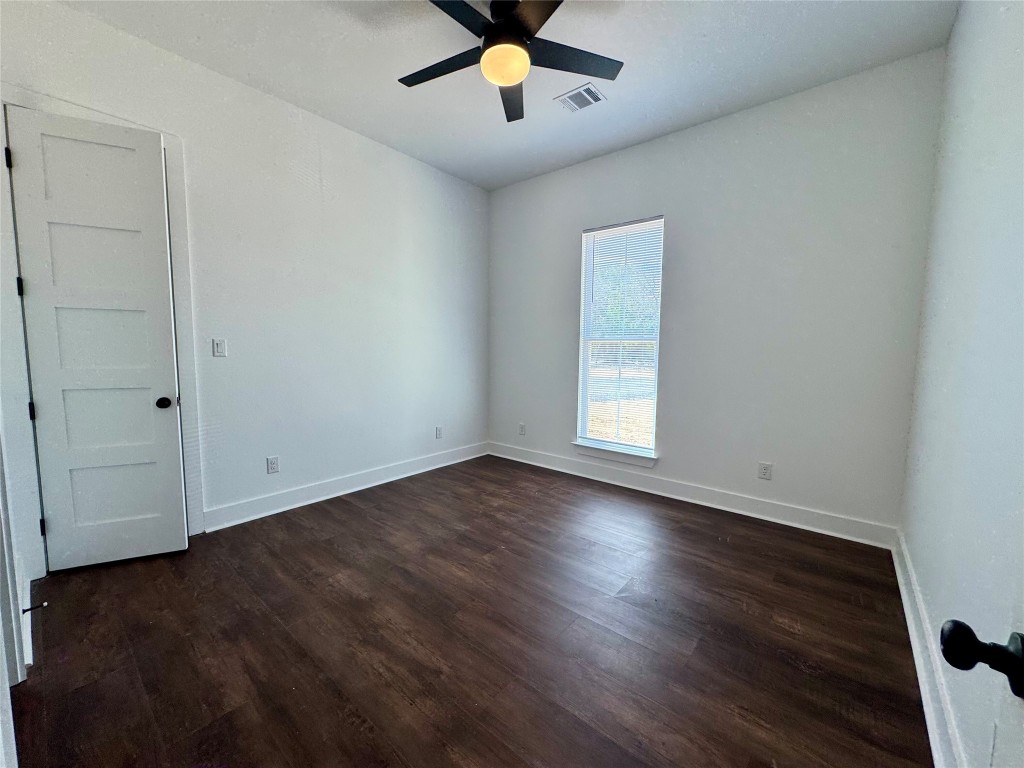 1353 Red Town Road, Unit B Elgin, TX 78621 - Photo 17 of 22 an empty room with wooden floor chandelier fan and windows