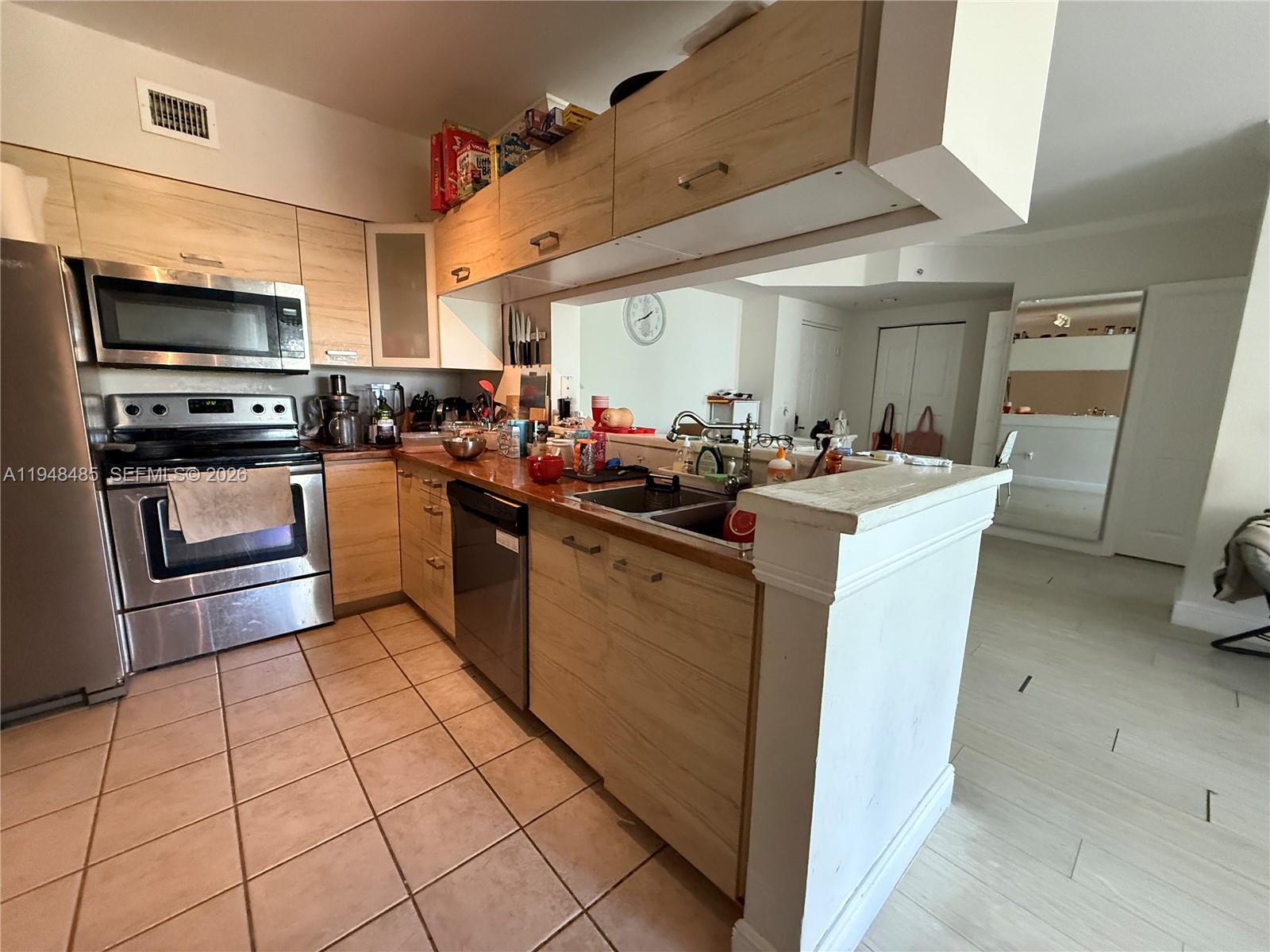 17145 North Bay Road, Unit 4506 Sunny Isles Beach, FL 33160 - Photo 4 of 10 a kitchen with stainless steel appliances a sink dishwasher stove top oven and cabinets