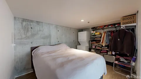 a bedroom with a bed a desk and a closet