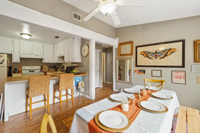 a kitchen with stainless steel appliances granite countertop a dining table chairs and a refrigerator