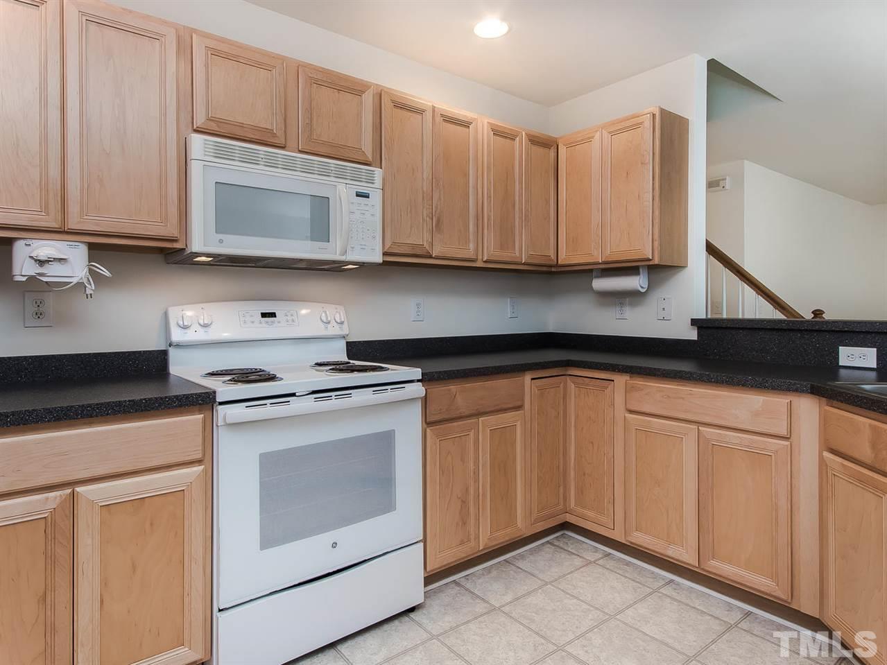 4720 Drewbridge Way Raleigh, NC 27604 - Photo 11 of 21 a kitchen with granite countertop white cabinets and white appliances