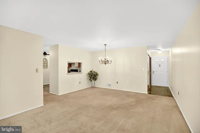 a view of a hallway with entryway and chandelier