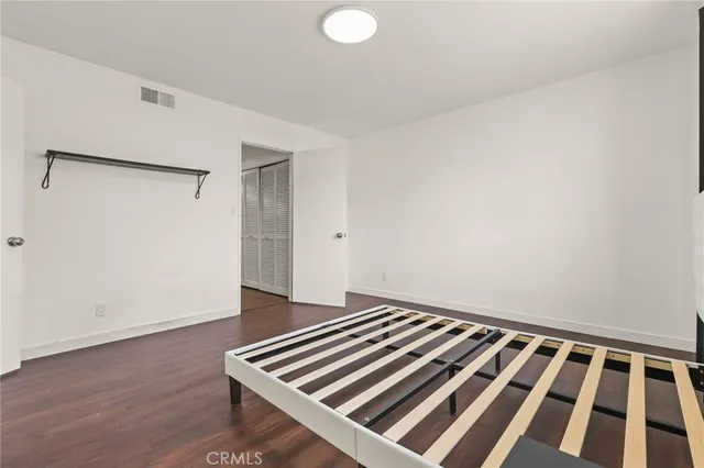 a view of an empty room with wooden floor and a cabinet