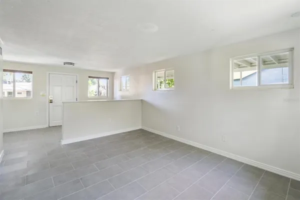 an empty room with windows and mirror