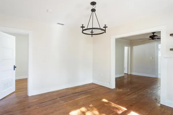 a view of a room with wooden floor and white walls