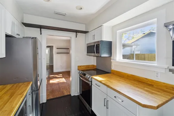 a kitchen with stainless steel appliances granite countertop a refrigerator and a stove top oven