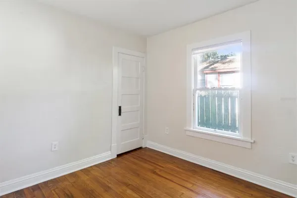 a view of an empty room with wooden floor