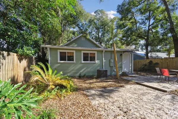 a front view of a house with a yard and potted plants