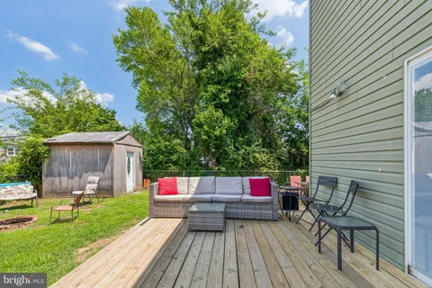 a view of a deck with couches table and chairs with wooden floor and fence