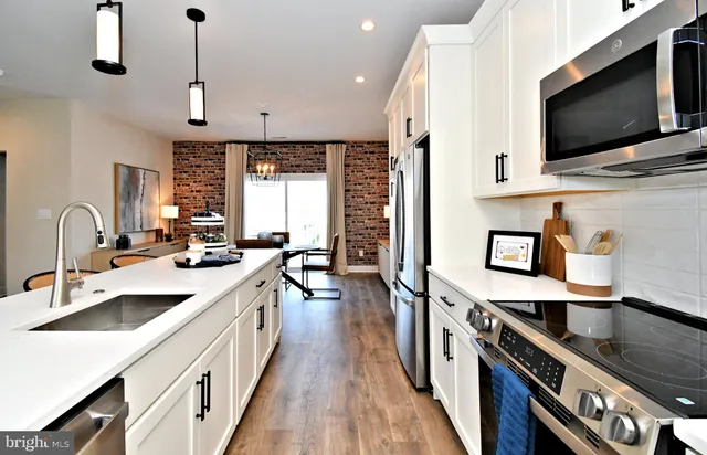 a kitchen with stainless steel appliances a sink a stove and a wooden floors