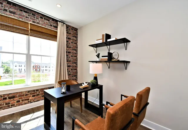 a view of a workspace with furniture and window