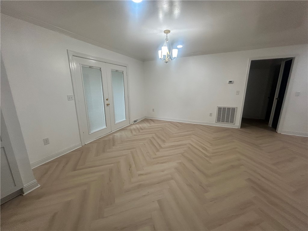 809 Paige Road Honea Path, SC 29654 - Photo 9 of 27 Herringbone pattern wood flooring graces this generously sized living space, illuminated by a classic chandelier.