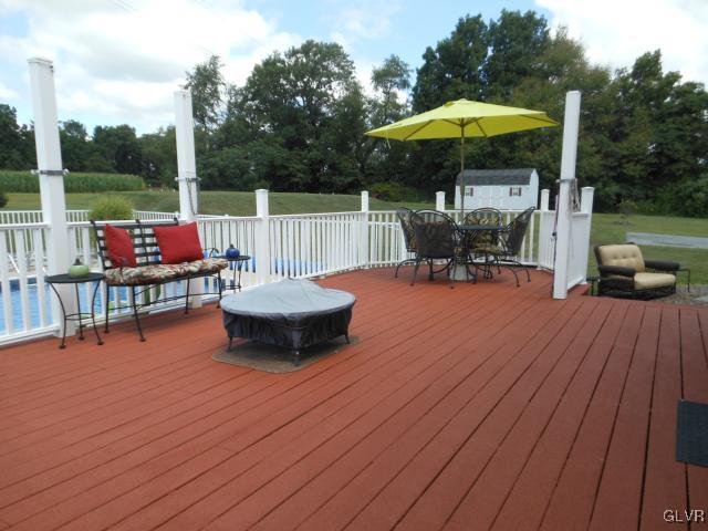 2768 Maefield Road Bath, PA 18014 - Photo 5 of 20 a view of a roof deck with table and chairs under an umbrella with wooden floor