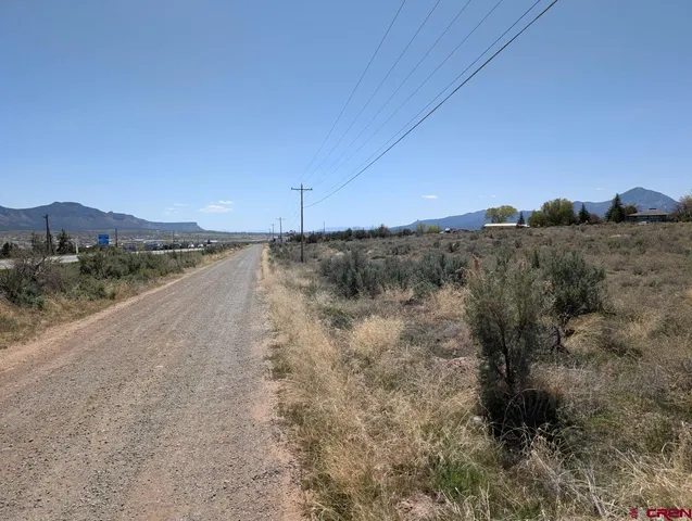 a view of a dry yard with mountains in the background