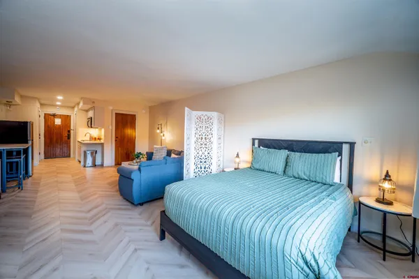 a bedroom with a large bed and a view of kitchen