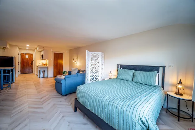 a bedroom with a large bed and a view of kitchen