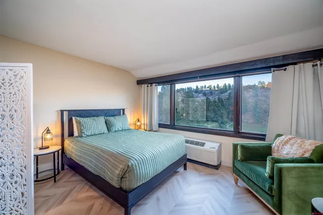 a bedroom with a bed and a large window