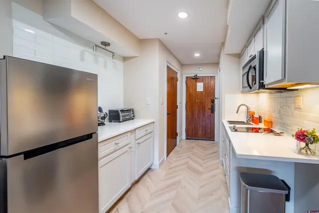 a kitchen with stainless steel appliances a refrigerator and a sink