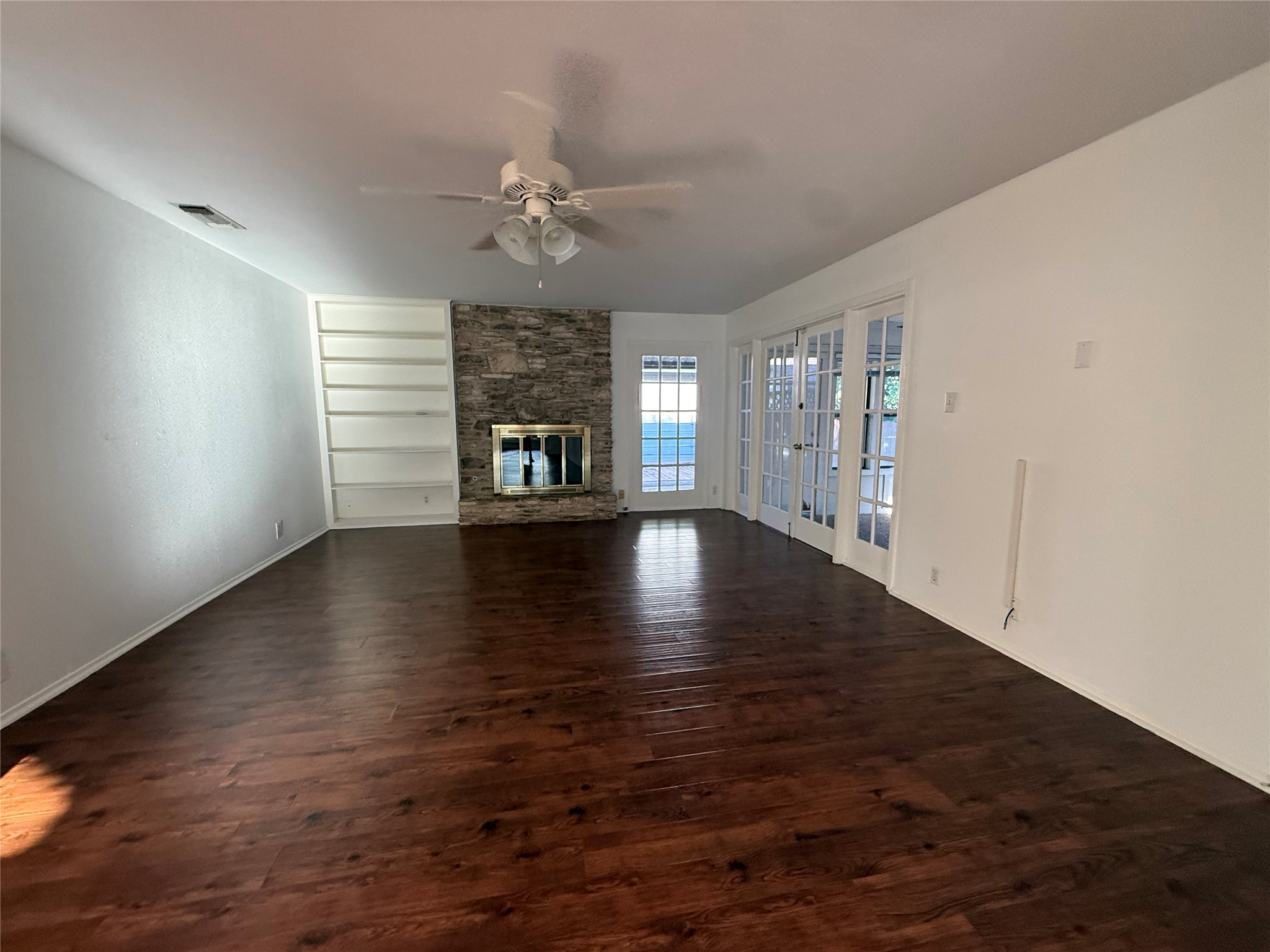 8713 Azalea Trail Austin, TX 78759 - Photo 13 of 13 Rich hardwood flooring complements a stone fireplace, creating a welcoming living space.