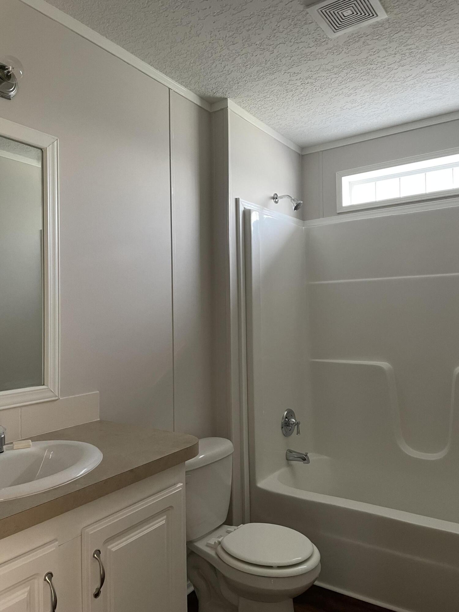 18459 260th Street Okeechobee, FL 34972 - Photo 14 of 15 a bathroom with a toilet a sink and shower