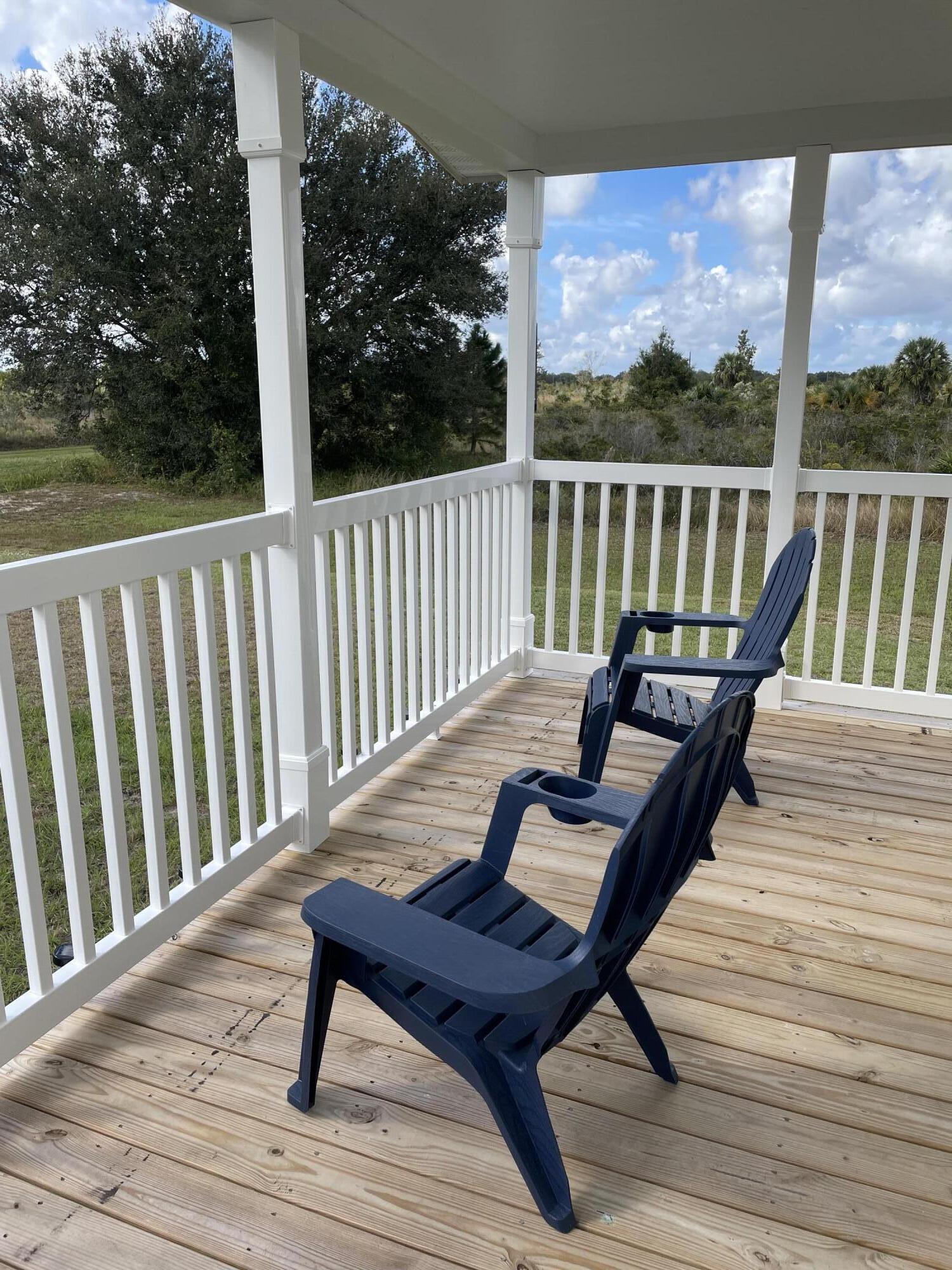 18459 260th Street Okeechobee, FL 34972 - Photo 5 of 15 a view of a chairs on wooden deck