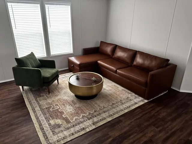 a living room with furniture a rug and a window