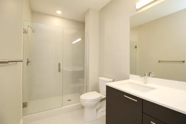 a bathroom with a sink a toilet and shower