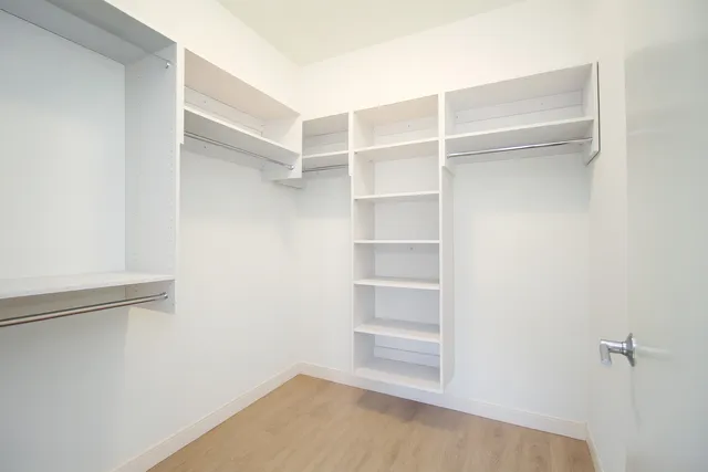 a view of walk in closet with empty racks
