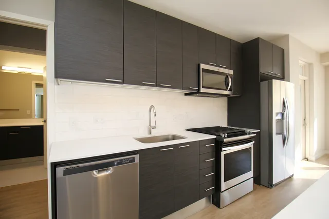 a kitchen with stainless steel appliances granite countertop a sink stove and microwave