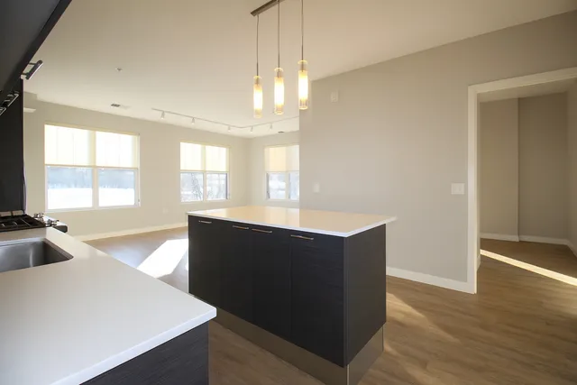 a view of kitchen with wooden floor and cabinets