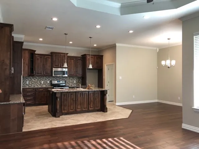 a kitchen with stainless steel appliances granite countertop a stove a sink and a refrigerator