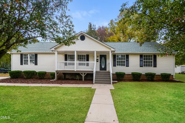 a front view of a house with a yard and green space