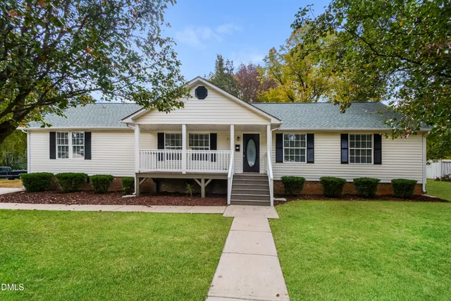 a front view of a house with a yard and green space