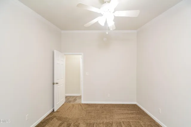 an empty room with a ceiling fan and a window