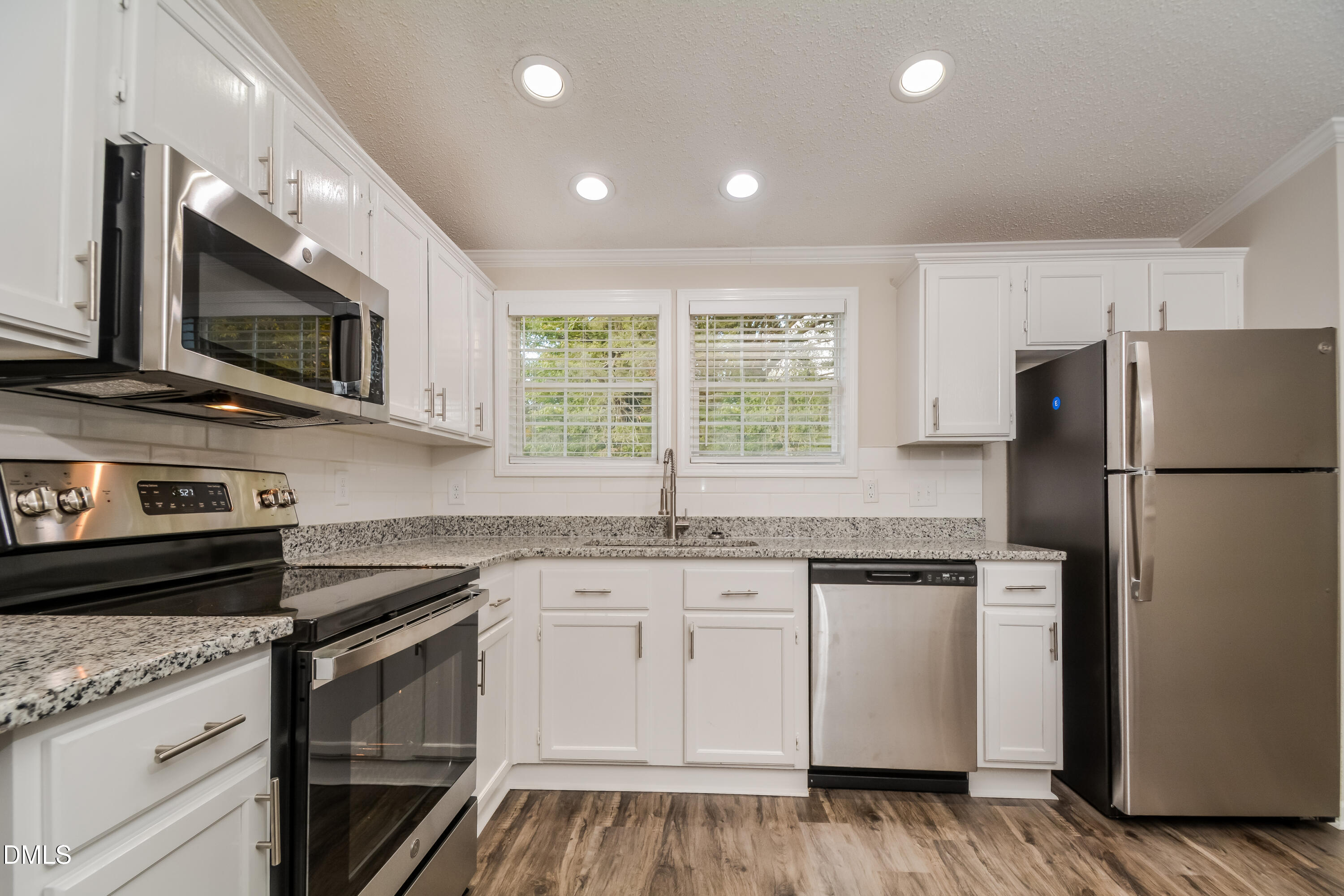 617 East Walnut Avenue Wake Forest, NC 27587 - Photo 4 of 16 a kitchen with stainless steel appliances granite countertop white cabinets a microwave a sink and a refrigerator