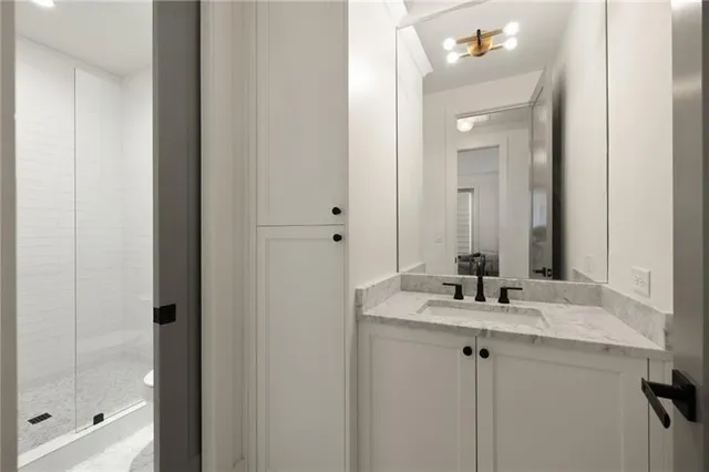 a bathroom with a granite countertop sink and a mirror
