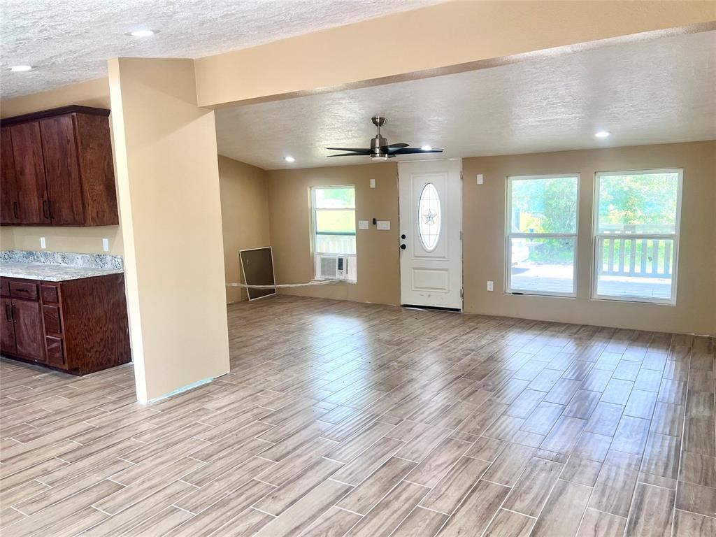 9115 Puritan Way Rosharon, TX 77583 - Photo 3 of 9 a view of an empty room with window and wooden floor