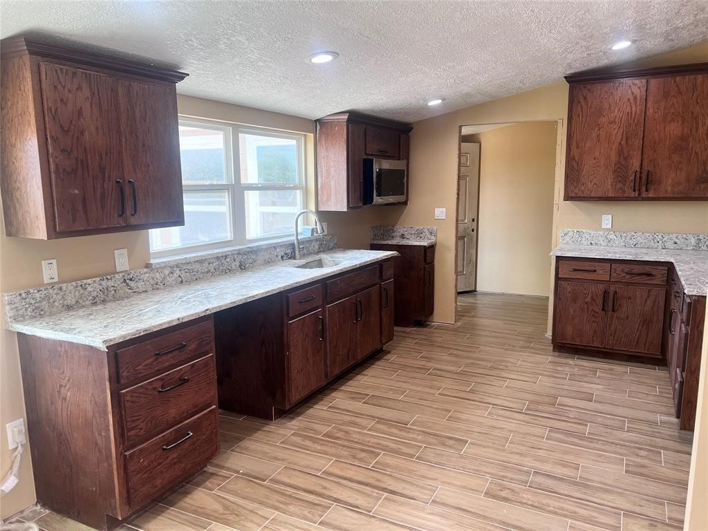 9115 Puritan Way Rosharon, TX 77583 - Photo 5 of 9 a kitchen with stainless steel appliances granite countertop a sink and cabinets