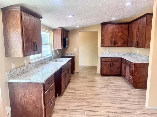 a kitchen with stainless steel appliances granite countertop wooden cabinets a sink and dishwasher