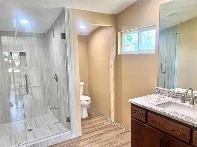 a bathroom with a sink a toilet and shower