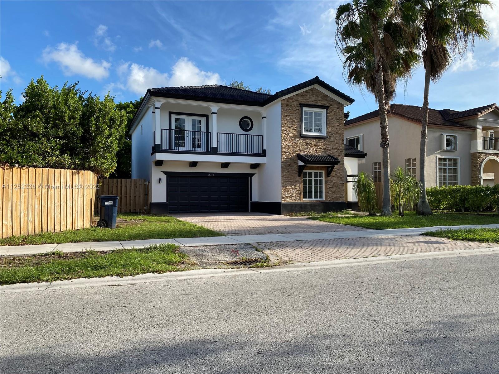 16350 Southwest 50th Terrace Miami, FL 33185 - Photo 1 of 59 a front view of a house with a garden and trees