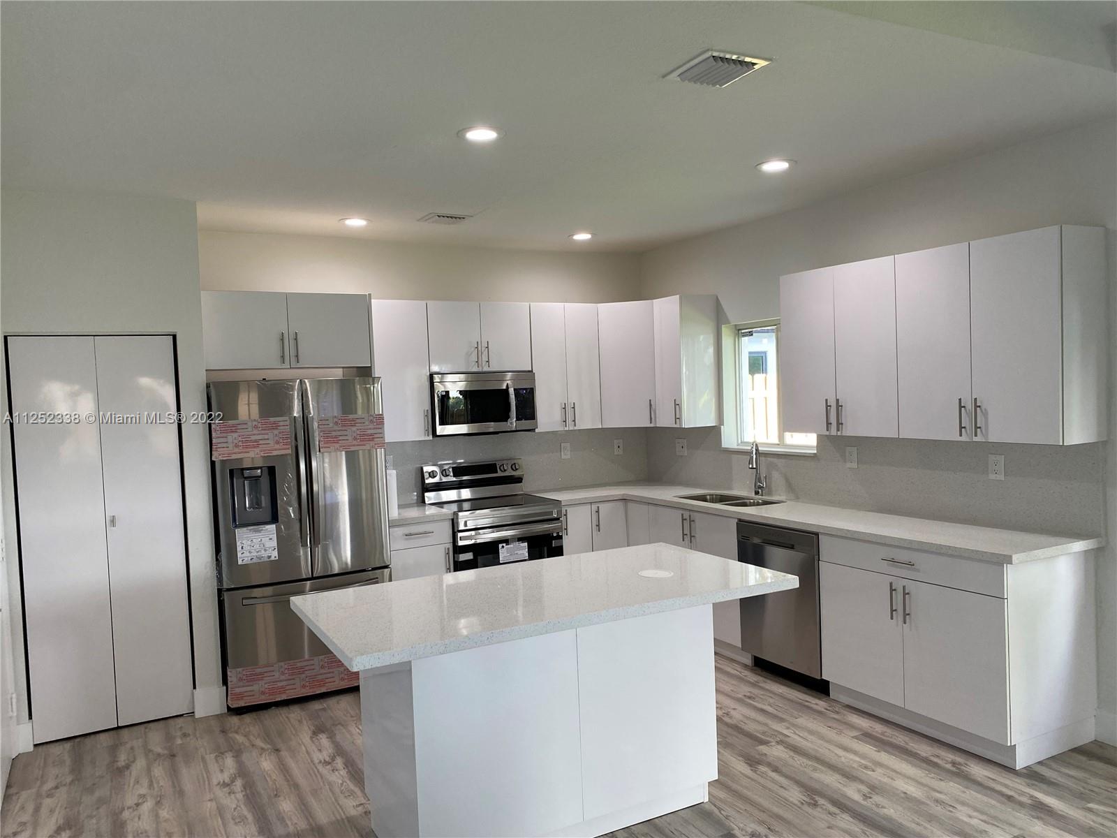 16350 Southwest 50th Terrace Miami, FL 33185 - Photo 14 of 59 a kitchen with stainless steel appliances a refrigerator stove microwave and sink