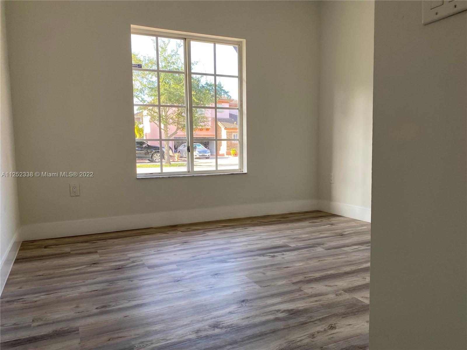 16350 Southwest 50th Terrace Miami, FL 33185 - Photo 16 of 59 an empty room with wooden floor and windows